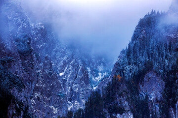 Wall Mural - Mountain peaks at  dawn with fog.