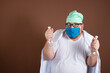 © vladorlov - Funny fat doctor with test tubes. Brown background.