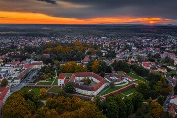 Wall Mural - Sarvar, Hungary - Aerial view of the Castle of Sarvar (Nadasdy castle) with Sarvar Arboretum, a beautiful dramatic sunrise and rain clouds at background on a calm autumn morning