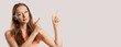 © Daria Lukoiko - Portrait of a smiling girl pointing finger to the side at on a white isolated background. Positive woman points to an idea, a place for advertising