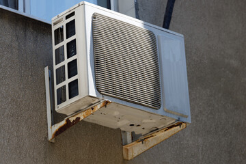 Poster - old air conditioner hangs on the wall of a residential building