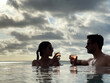 Lovely couple celebrating live in a natural pool with oceanfront panoramic view of the sunset in a tropical place