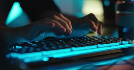 computer hands typing on keyboard programmer coding hacking data on internet cyber crime information hack by anonymous hacker using rgb gaming keyboard with blue backlight