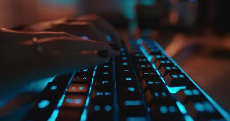 close up hands typing on keyboard programmer coding software gamer using keyboard with blue backlight playing game at night