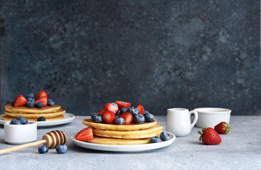 Canvas Print - Homemade pancakes with strawberries and blueberries for breakfast on the kitchen table.