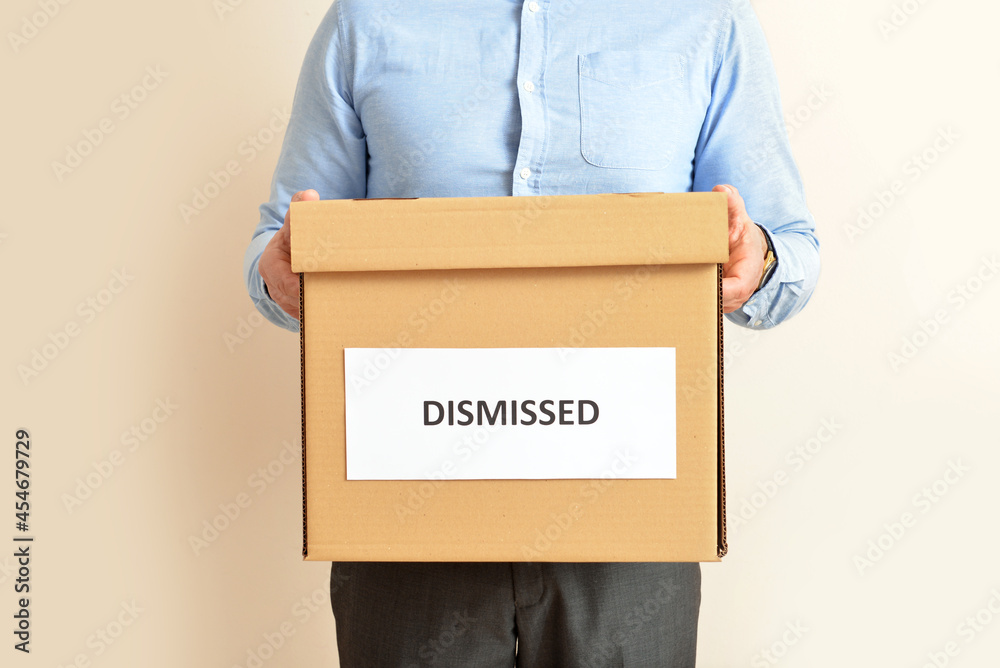 Man holding box with word DISMISSED on color background