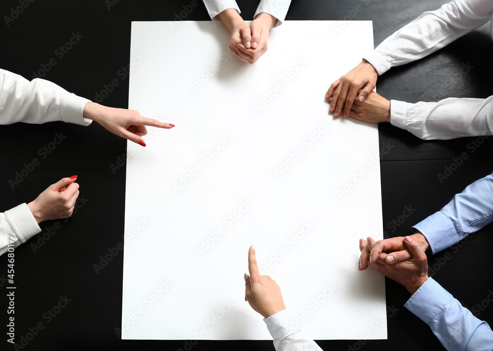 Group of people with blank poster on table