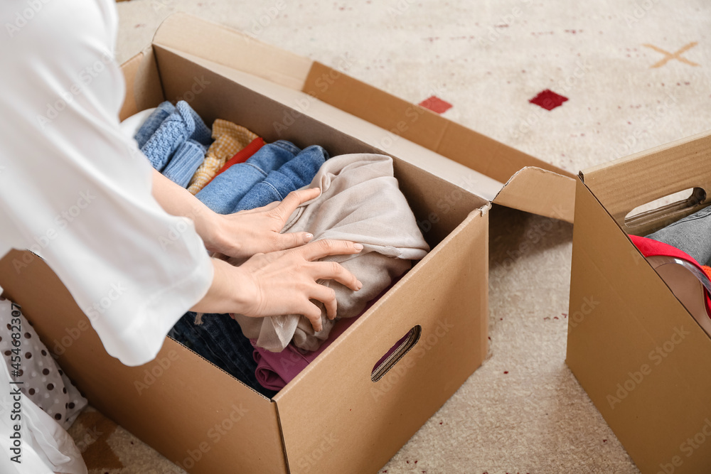 Young woman packing clothes in dressing room