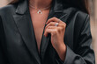 Female hands in a black stylish leather jacket and silver accessories on a female body. Jewelry and women's fashion
