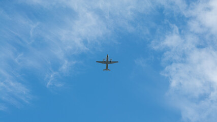 Wall Mural - View of propeller plane flying with blue sky and clouds. Airplane fly