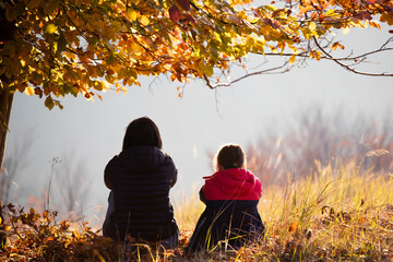 Wall Mural - Family portrait. Motherr with daughter in autumn landscape.