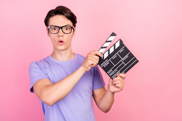 Sticker - Portrait of attractive amazed guy filmmaker assistant using board producing movie isolated over pink pastel color background