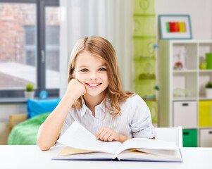 Wall Mural - education and school concept - happy smiling student girl reading book over home background