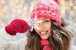 © Syda Productions - people, season and christmas concept - portrait of happy smiling teenage girl or young woman with snowflake in winter over festive lights background