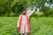 © PRASANNAPIX - Young indian farmer standing in cotton agriculture field.