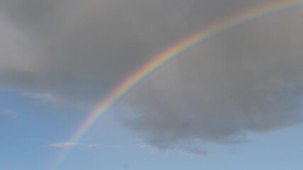 Wall Mural - natural phenomenon bright colorful rainbow in the clouds