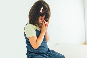 Wall Mural - Cute little girl praying at home