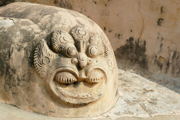 Poster - Engraved sculpture on yellow stone with a wall background