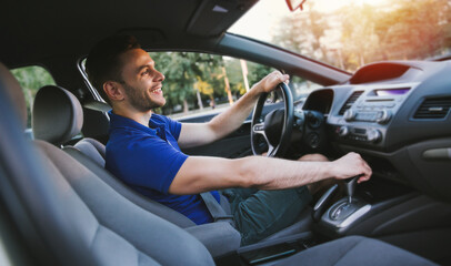 Close up photo of young handsome successful man is driving his modern car