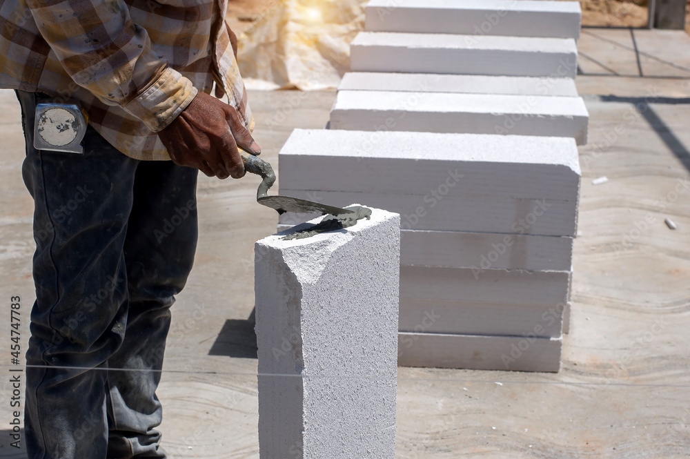 masonry worker make concrete wall by cement block and plaster at ...