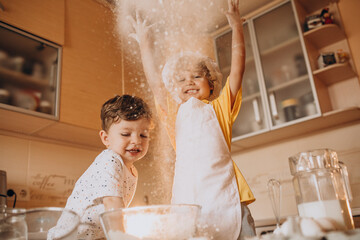 Two little brothers baking at the kitchen