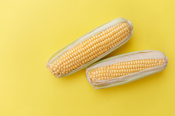 Wall Mural - Fresh corn on yellow nackground. Concept on healthy eating.