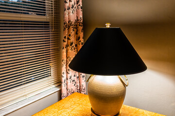 Poster - Rustic living room with electric lamp light nightstand on table by window blinds with curtains in cottage home house old interior design in evening