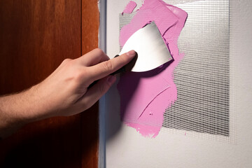putty knife application of spackling compound or damaged drywall patch