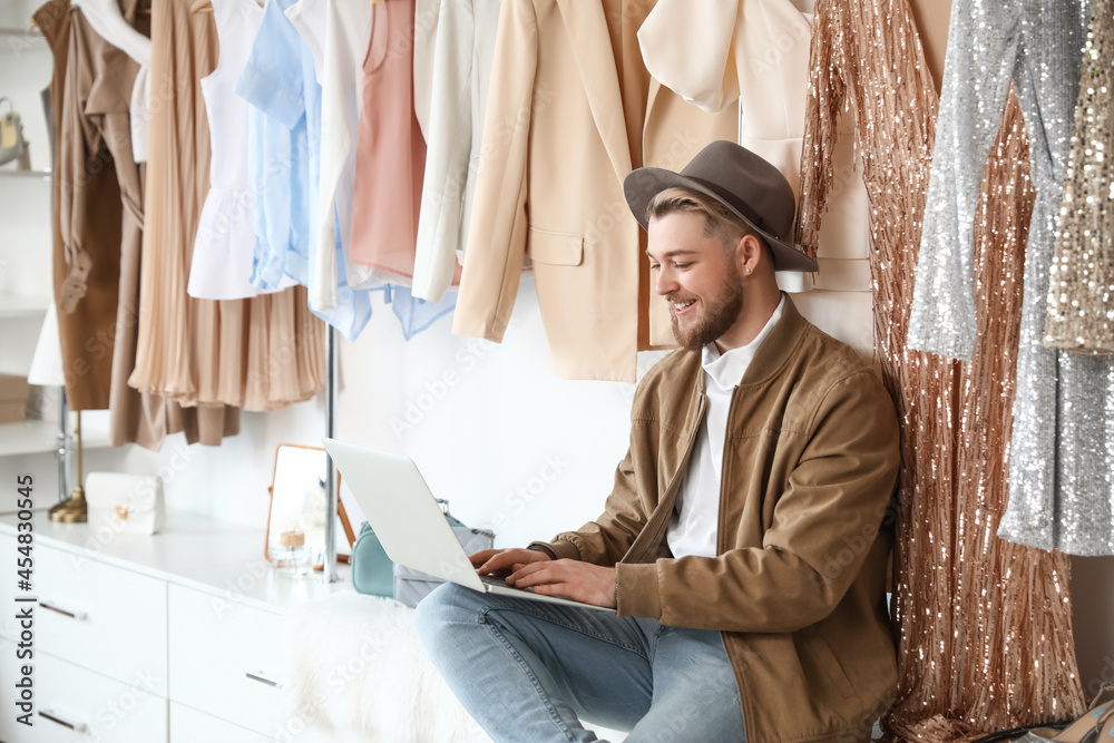 Male stylist using laptop in studio