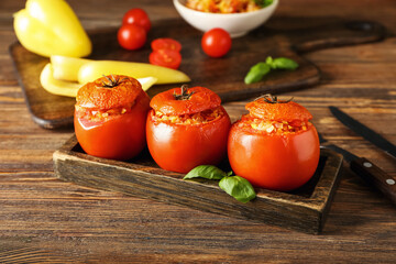 Board with tasty stuffed tomatoes on wooden background