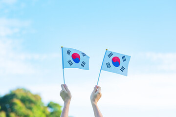 Wall Mural - hand holding Korea flag on nature background. National Foundation, Gaecheonjeol, public Nation holiday, National Liberation Day of Korea and happy celebration concepts