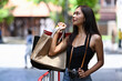 © Prathankarnpap - Attractive Asian woman holding shopping bags and walking in a city.