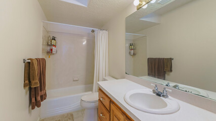 Wall Mural - Pano Interior of a bathroom with wall lightning, vanity sink and bathtub