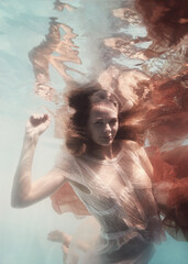 Wall Mural - Girl in a white dress and with a red cloth emotional portrait underwater