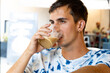 © URI - Young brunette boy in patterned shirt and coconut earring drinking coffee