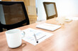 © Ratchapon - Coffee cup ,paperwork and notebook on table with two black armchairs in meeting room