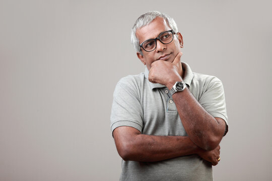 Mature man of Indian ethnicity with a thoughtful expression
