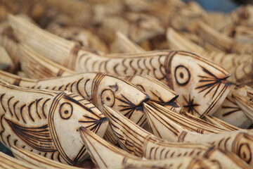 Canvas Print - Beautiful closeup of wooden handcraft fish structures being sold at the market