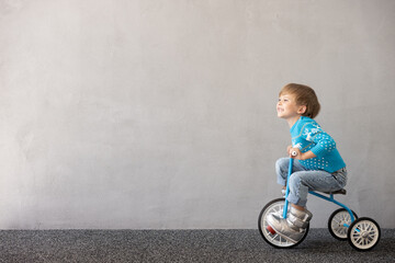 Canvas Print - Happy child riding bike. Christmas holiday concept