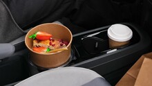 Take Away Coffee Cup And Cottage Cheese Casserole Dessert With Strawberries, Pomegranate Seeds On Panel Of Automobile In Car Holder. Multitasking Driving Concept. Coffee To Go, Take Away Healthy Break