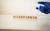 Fototapeta  - Szczepienia - napis z drewnianych kostek, szczepionka,  strzykawka, rękawica