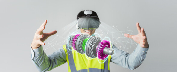 Asian man Engineer wearing VR headset design machine part Automatic Gear Transmission project on banner. Innovation futuristic virtual reality design of mixed Technology Application. Selective focus.