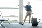 Fototapeta Łazienka - Young woman pulling luggage at the airport, close up sexy legs