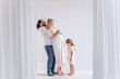 © farmuty - Young modern family have fun together in white loft interior. Mother pregnant, father holds daughter