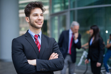 Sticker - Smiling businessman in front of a blue glass background