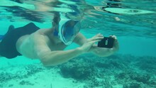 Close Up View Of Man With Mobile Phone Filming Under Water. Snorkeling.  Maldives.