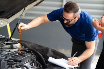 Sticker - Auto mechanic worker checking oil level in car engine. Car maintenance and auto service garage concept.