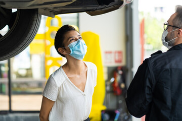 Sticker - Mechanic man and woman customer wearing medical face mask protection coronavirus and check the car condition before delivery.