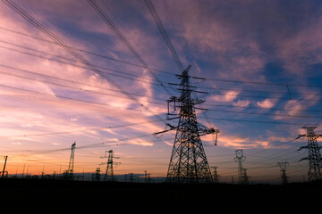 Wall Mural - A silhouette of an electric tower against a beautiful sunset background