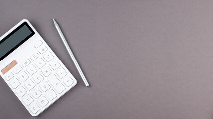 Poster - Overhead view of work desk with calculator and pen on grey background , copy space